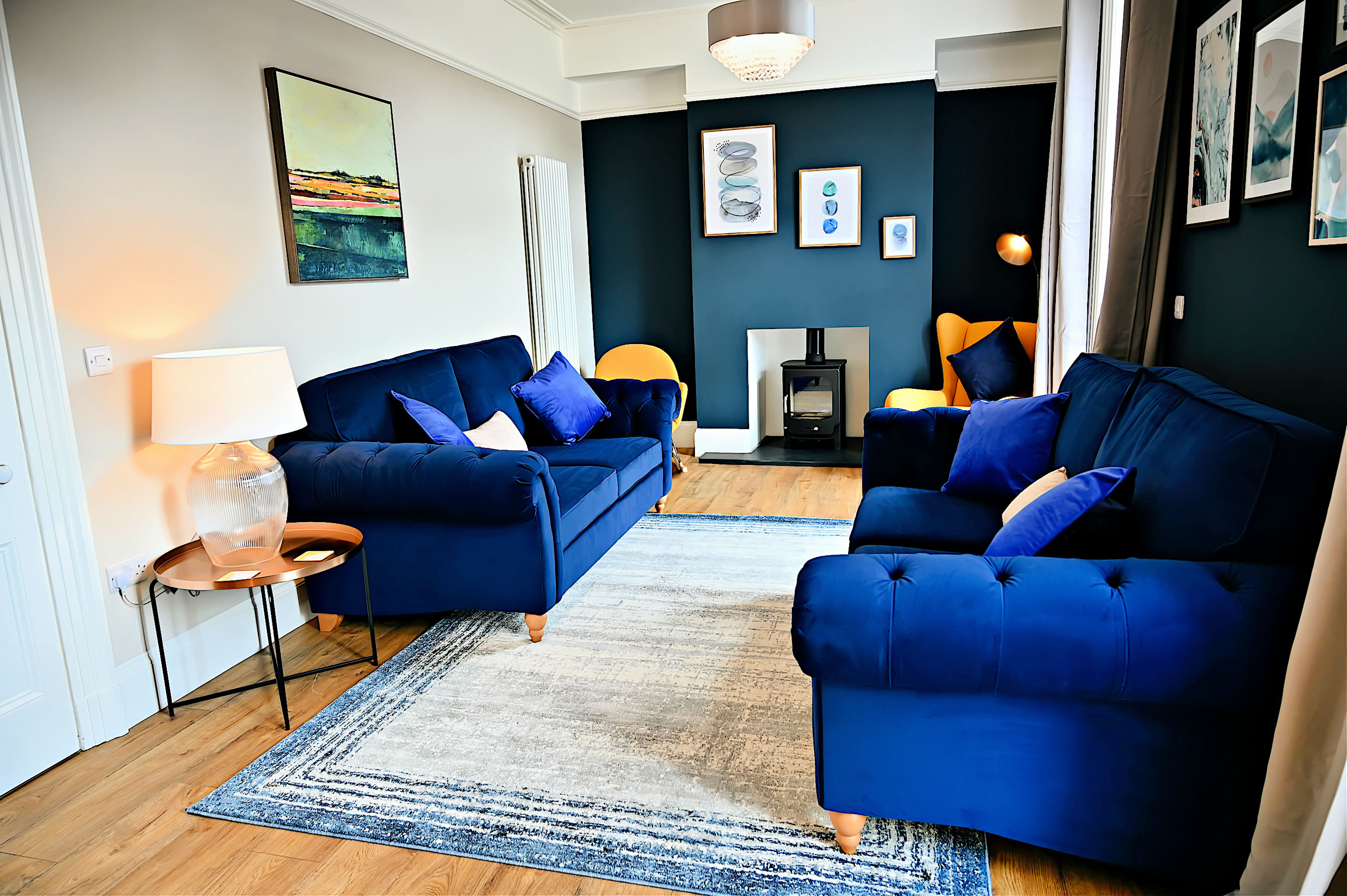 Rhydwenfa - living room with cosy Chesterfields and a wood burning stove