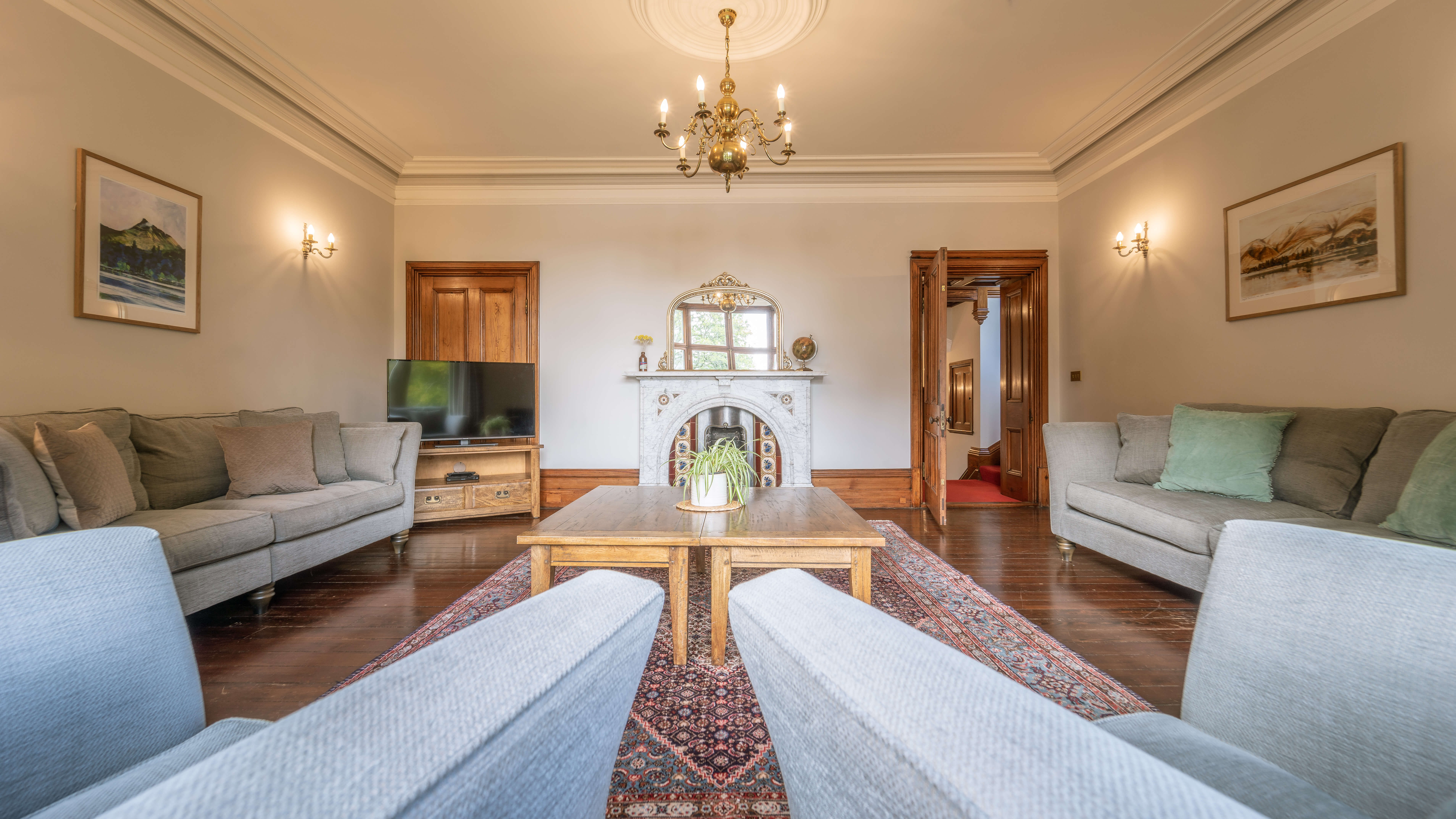 Rosetrees - lounge with high ceilings and open fireplace