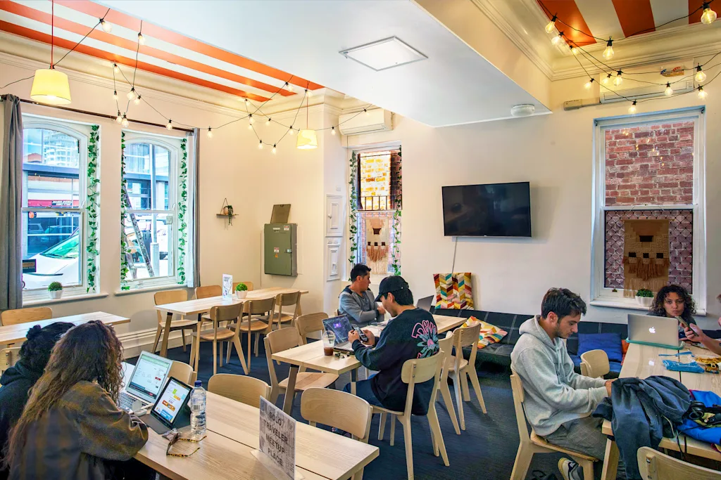 Tequila Sunrise Hostel - communal dining and work space with TV