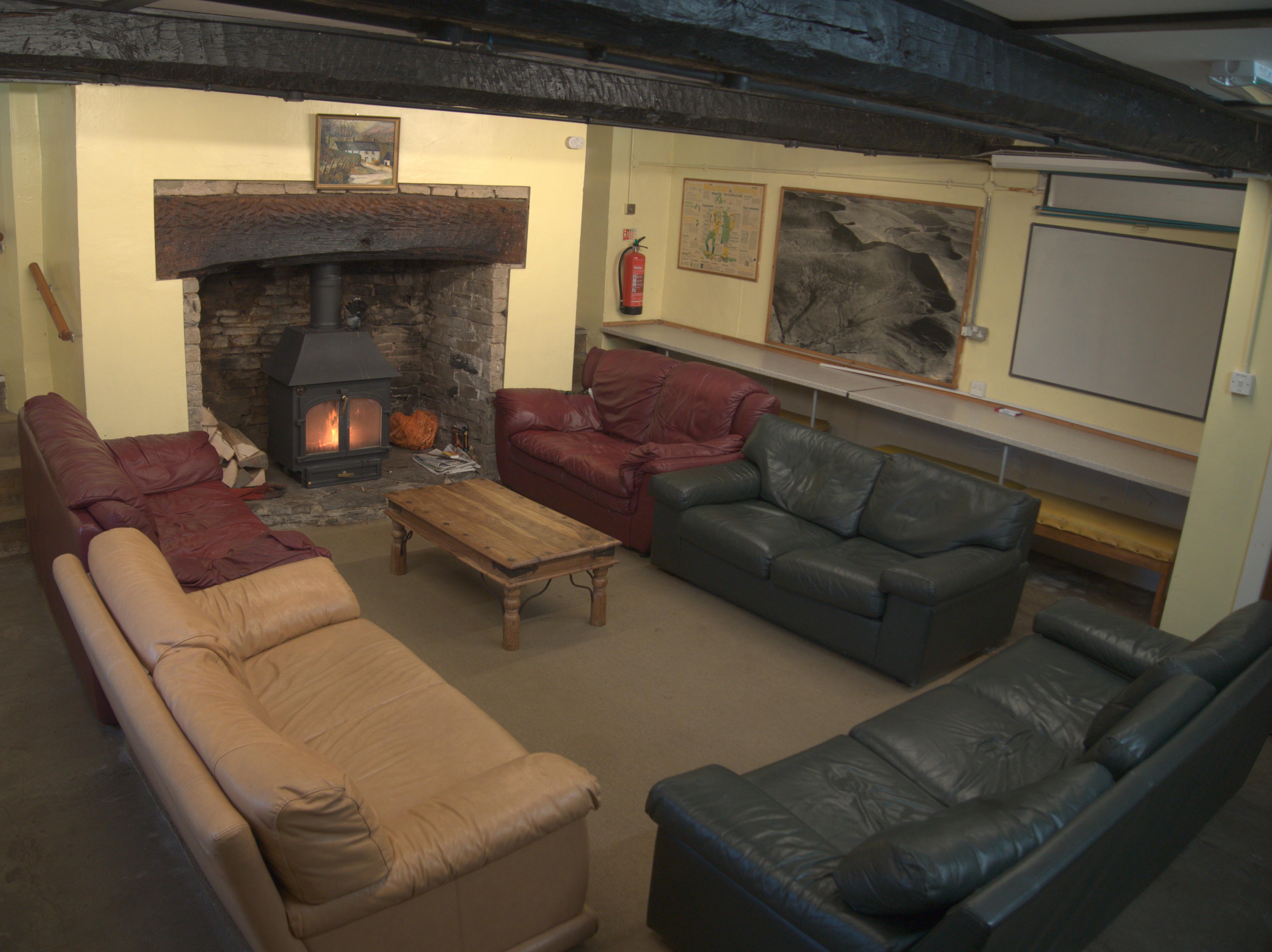 Brecon Forest Farmhouse - cosy lounge with sofas and woodburner