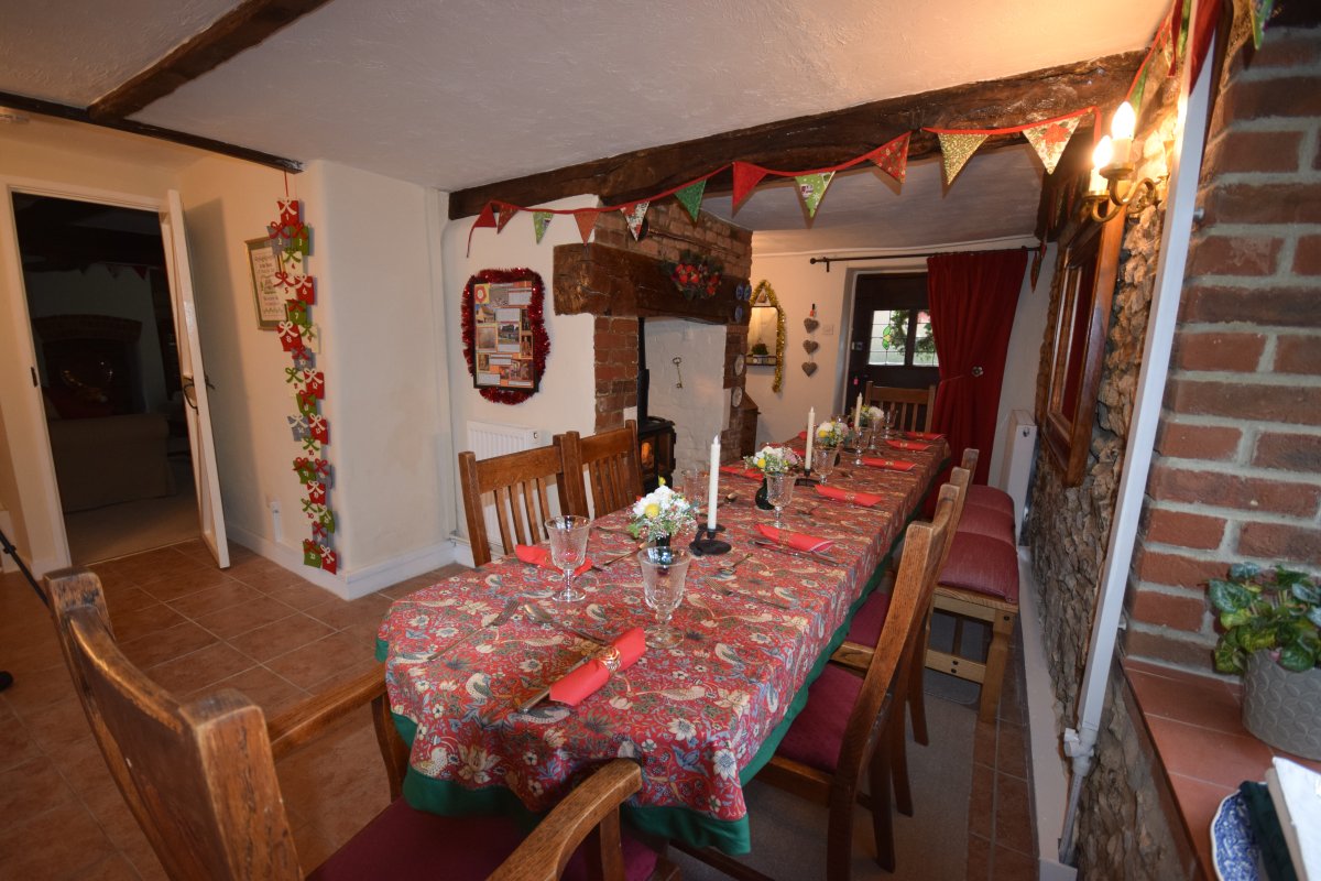 Dining room has flame effect electric stove in inglenook