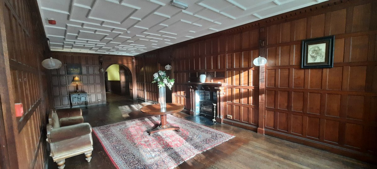 The oak-panelled entrance hall glowing in the afternoon sunshine