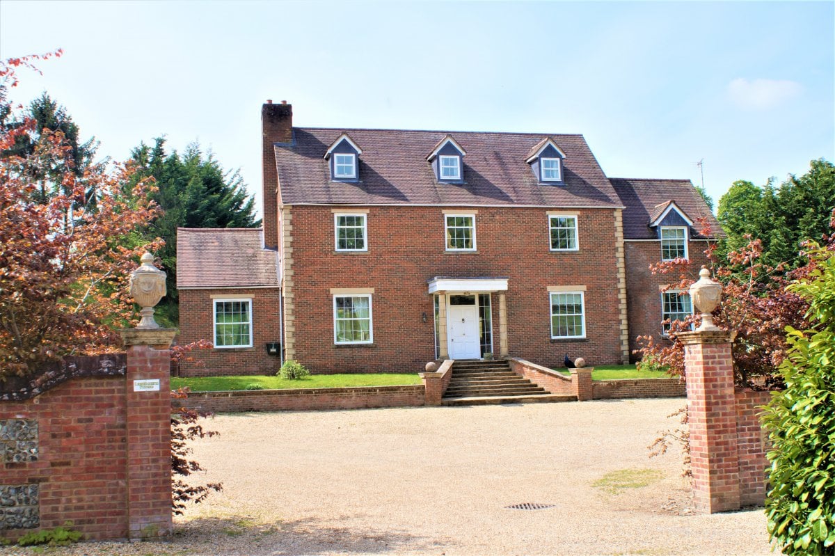 Front of house with large parking area.