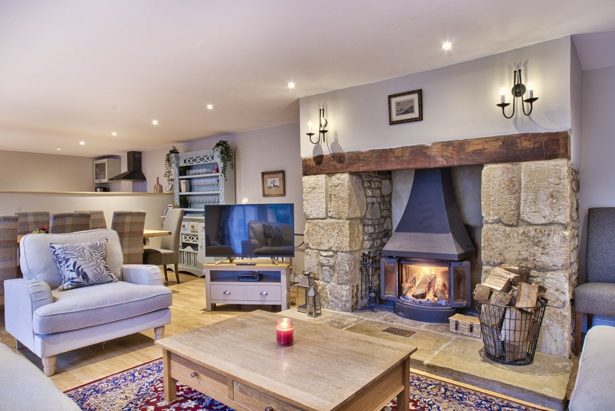 Relax next in open plan living room with wood burner at Olive Cottage