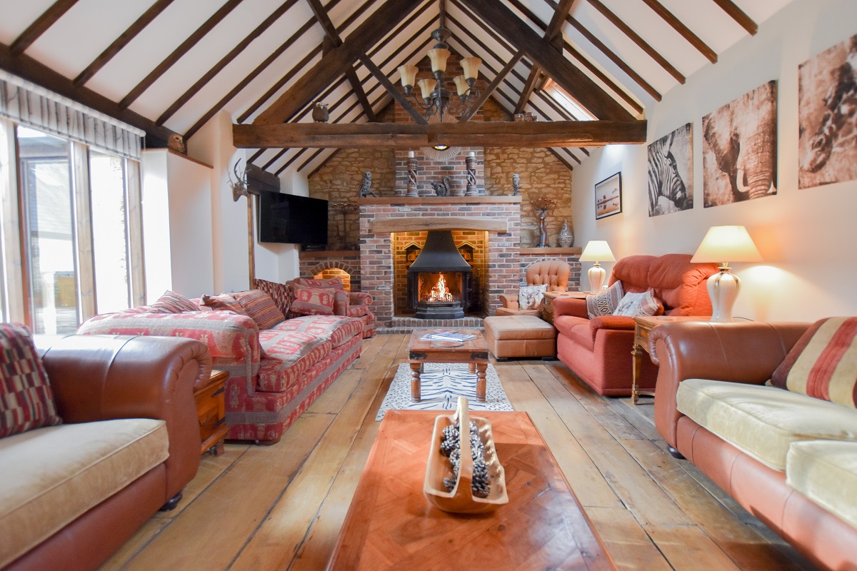 The vaulted and beamed sitting room with large inglenook fireplace and wood burning stove