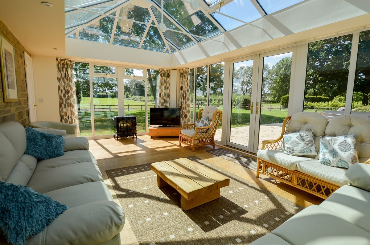 The stunning conservatory/sitting room enjoys far reaching views across parkland and a vineyard