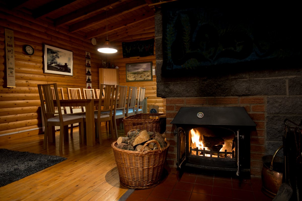 Large dining table and wood burner at Our Cabin in the Wood