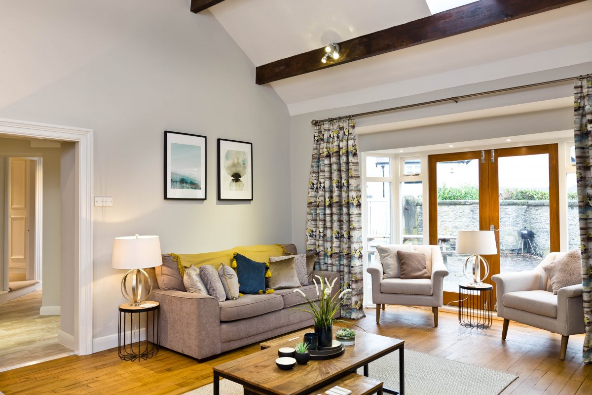 Bright and airy living room with patio doors leading out to the courtyard area