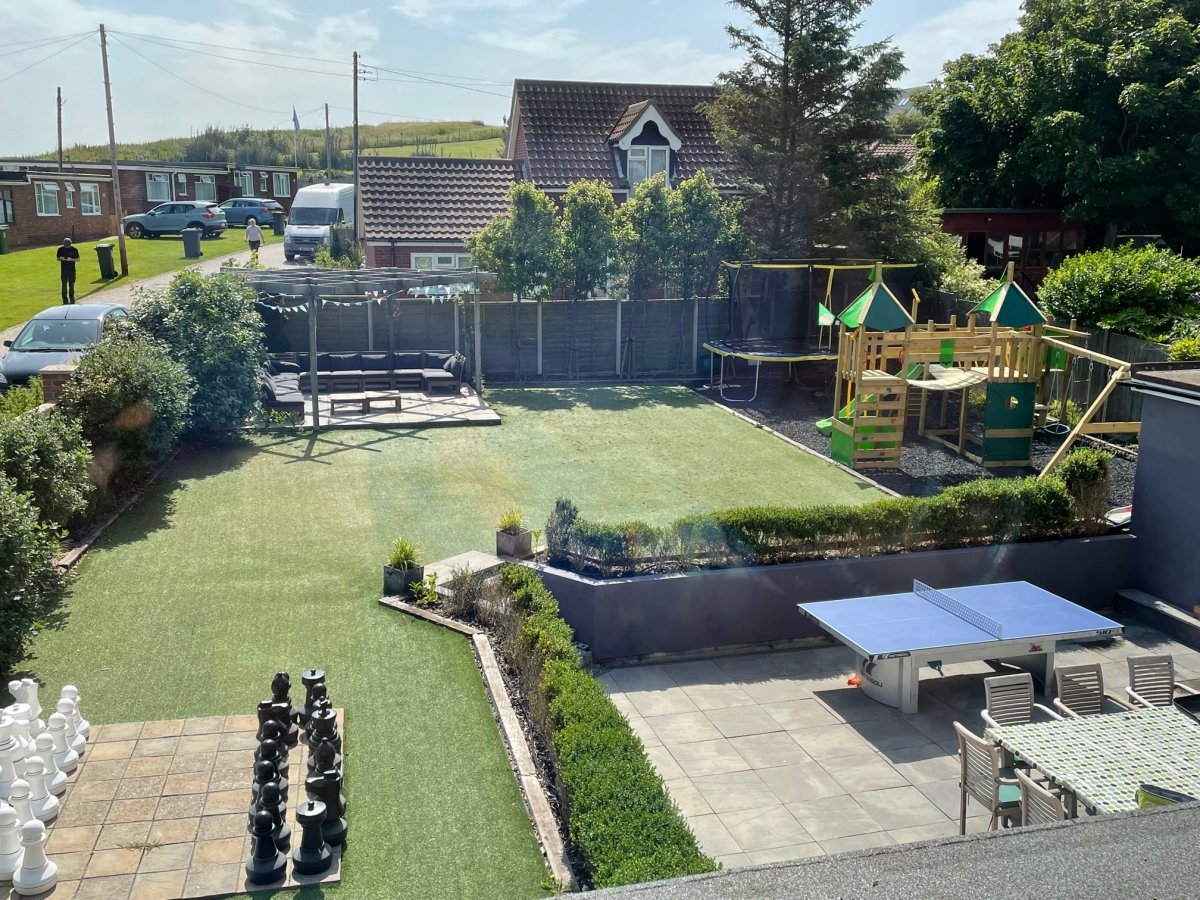 Our garden, with a sofa area, giant chess, table tennis, childrens play area with trampoline