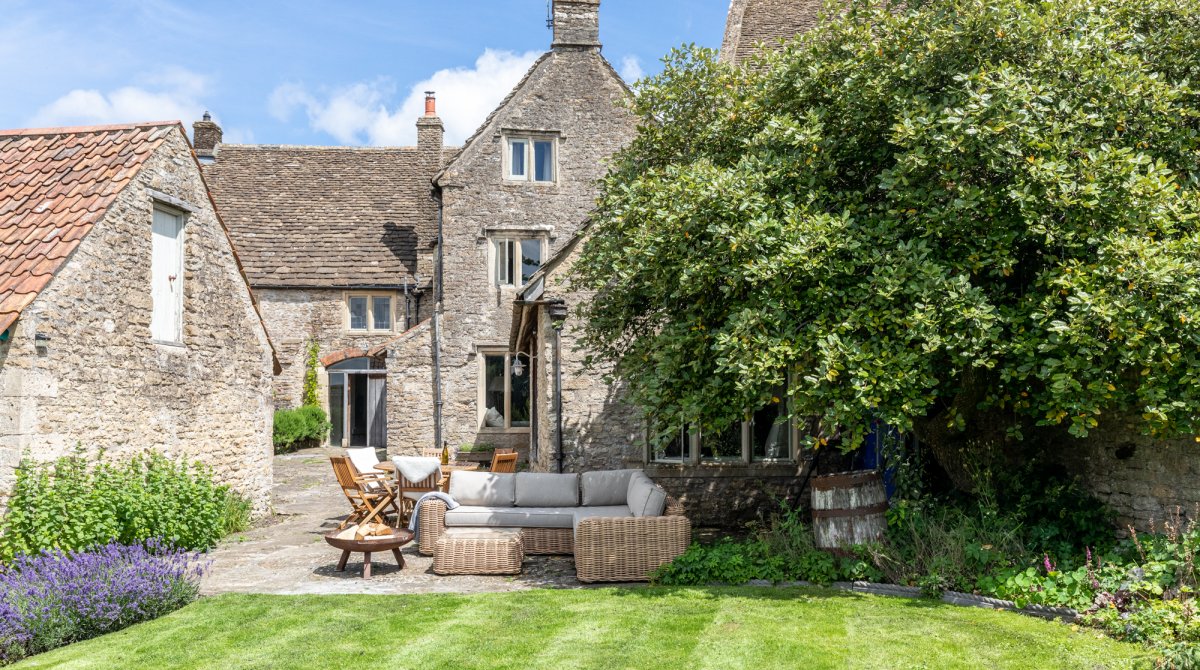 The Malthouse - external view of mature gardens and lawn