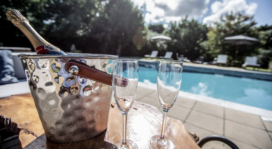 Swimming pool with bottle of champagne on the table