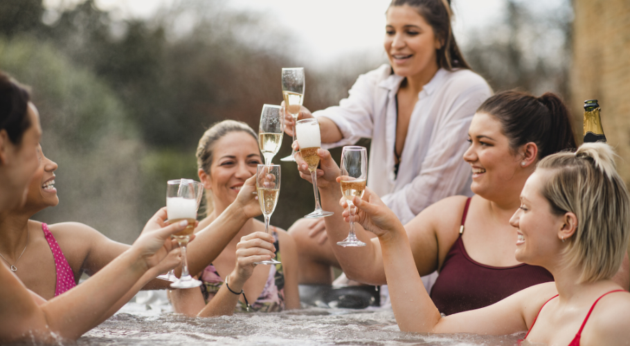 Women enjoying champagne in hot tub