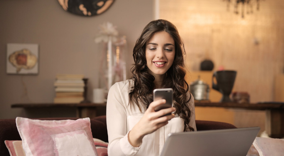 Woman sat on her couch looking at her phone